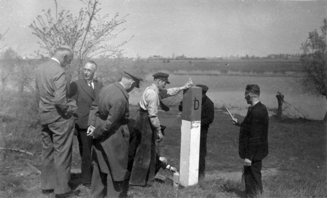 Plaatsing nieuwe grenspaal tussen Wyler en Beek door grenscorrectie, 23 april 1949.